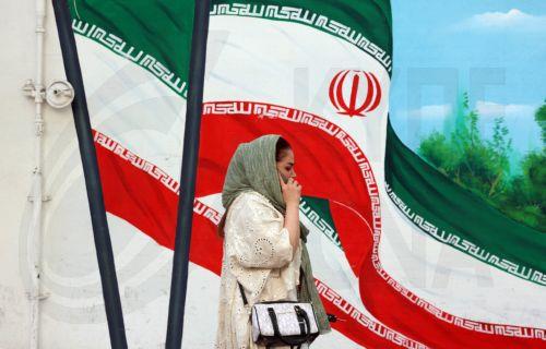 epa12121608 An Iranian woman walks past a wall painting of Iran's national flag in Tehran, Iran, 21 May 2025. Iran and US talks have paused as both sides made remarks against each other in recent days. According to the Iranian Foreign Ministry, Iranian Foreign Minister Abbas Araghchi said on 21 May 2025 that they are evaluating whether to participate in the...