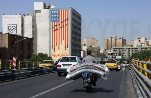 epa12121612 Motorists drive past an anti-US mural in Tehran, Iran, 21 May 2025. Iran and US talks have paused as both sides made remarks against each other in recent days. According to the Iranian Foreign Ministry, Iranian Foreign Minister Abbas Araghchi said on 21 May 2025 that they are evaluating whether to participate in the next round of negotiations....