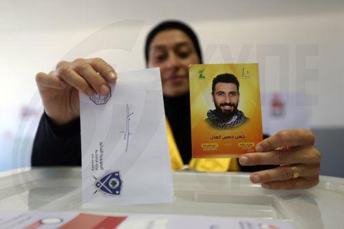 epa12129984 A Lebanese woman carries a picture of her husband who was killed in the conflict between Hezbollah and Israel as she casts her ballot during the municipal elections at a polling station in Nabatieh, southern Lebanon, 24 May 2025. The final phase of the Lebanese municipal elections is being held on 24 May after they were postponed in 2023 due to...