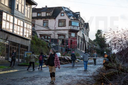 epa12136058 People look at the damage caused by a tornado in Puerto Varas, Chile, 25 May 2025. More than fifteen thousand homes remain without electricity and other basic supplies in the tourist city of Puerto Varas, in southern Chile, after being hit by a tornado that destroyed more than a hundred houses and left a dozen injured.  EPA/FELIPE CONSTANZO