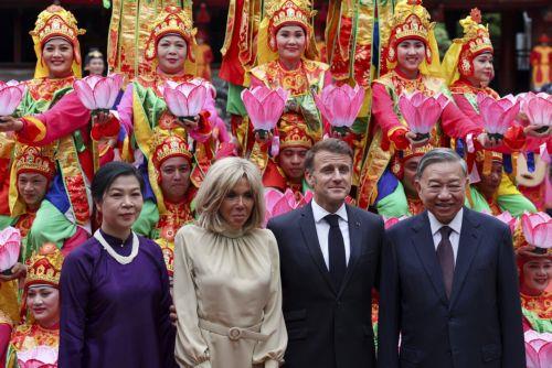 epa12136208 Vietnam's Communist Party General Secretary To Lam and his wife, Ngo Phong Ly, and French President Emmanuel Macron and his wife, Brigitte Macron, pose for a picture with traditional dance performers during a luncheon at Van Mieu, in Hanoi, Vietnam, 26 May 2025.  EPA/Chalinee Thirasupa / POOL