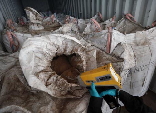 epa12167600 A Thai Customs official examines confiscated hazardous Electric Arc Furnace (EAF) Dust or 'red dust' hidden inside shipping containers at the Customs X-Ray and Technology Center, Bangkok Port Customs Office in Bangkok, Thailand, 10 June 2025. Thai authorities seized 736 tons of Electric Arc Furnace (EAF) dust, or 'red dust', concealed in 36...
