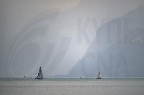 epa12169917 A haze of smoke from Canadian wildfires blankets the sky and mountains at the Urnersee in Brunnen, Switzerland, 11 June 2025. The smoke, originating from wildfires in the Canadian Manitoba and Saskatchewan provinces, crossed the Atlantic, according to the Copernicus Atmosphere Monitoring Service (CAMS).  EPA/URS FLUEELER