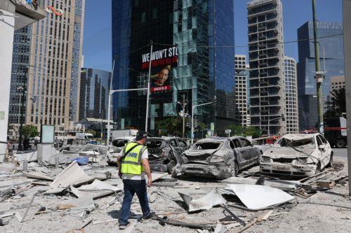 epa12184833 An Israeli police officers walks among debris near damaged cars at the site of an Iranian missile strike in a residential area in Ramat Gan, central Israel, 19 June 2025. Israel's military stated Iran launched a barrage of ballistic missiles at Israel overnight. Magen David Adom (MDA), Israel's national emergency services, reported dozens of...