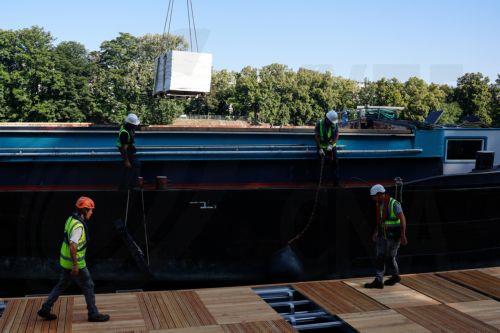 epa12185101 Workers operate on the construction site of the future Grenelle swimming site on the Seine River bank, in the Port de Grenelle, in Paris, France, 19 June 2025. Parisians will be able to swim in the Seine river from 05 July until 31 August 2025, with three swimming sites preparing to open for the public as part of Paris Plages 2025.  EPA/MOHAMMED...