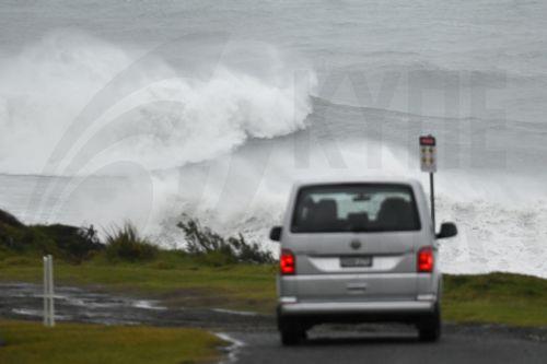 epa12209369 A vehicle drives near a large swell battering the coast in Wollongong, New South Wales, Australia, 02 July 2025. Parts of New South Wales have had rainfall totals of more than 120mm in one day and authorities warn the coming 24 hours could be even worse.  EPA/DEAN LEWINS  AUSTRALIA AND NEW ZEALAND OUT