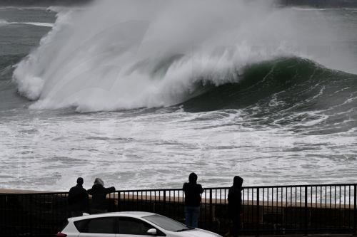 epa12209466 Onlookers watch large swells batter the coast at Wollongong Harbour in Wollongong, New South Wales, Australia, 02 July 2025. Parts of New South Wales have recorded more than 120 mm of rain in a single day, and authorities warn that the next 24 hours could bring even worse conditions.  EPA/DEAN LEWINS NO ARCHIVING AUSTRALIA AND NEW ZEALAND OUT