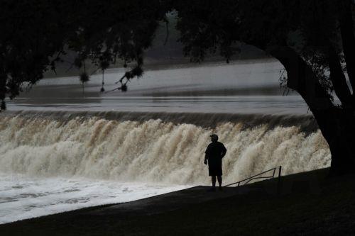 epaselect epa12219270 People watch the Guadalupe River flow over a dam, where the river measured 34.29 feet (10.5 meters) at its crest on 04 July, in Kerrville, Texas, USA, 05 July 2025. Early 04 July, floodwaters swept through a summer camp and nearby homes, killing at least two dozen people, with dozens of campers still unaccounted for.  EPA/DUSTIN...