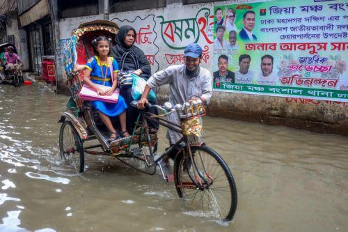 epa12226234 A rickshaw puller rides his rickshaw in a flooded street during a rainy day, in Dhaka, Bangladesh, 09 July 2025. The Bangladesh Meteorological Department (BMD) has forecasted rain or thunder showers in all divisions, including Dhaka. Monsoon is active over Bangladesh and strong over North Bay.  EPA/MONIRUL ALAM
