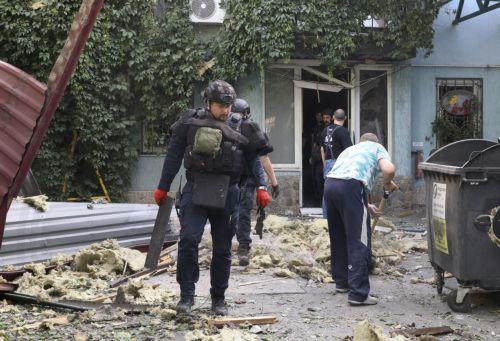 epa12231056 Ukrainian experts work at the site of a drone strike in Kharkiv, Ukraine, 11 July 2025, amid the Russian invasion. At least nine people were injured the morning in a Russian drone attack on downtown Kharkiv, according to the State Emergency Service (SES).  EPA/SERGEY KOZLOV
