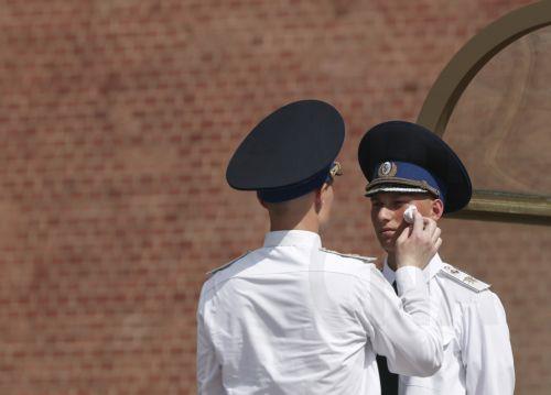 epa12232108 A Russian honour guard officer refreshes an honour guard serviceman at the Tomb of the Unknown Soldier near the Kremlin wall during a hot summer day, in Moscow, Russia, 11 July 2025. Temperatures in the Moscow region reached more than 36 degrees Celsius.  EPA/SERGEI ILNITSKY