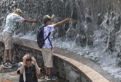 epa12232127 People cool off in a fountain on a hot summer day in downtown Moscow, Russia, 11 July 2025. Temperatures in the Moscow region reached more than 36 degrees Celsius.  EPA/SERGEI ILNITSKY
