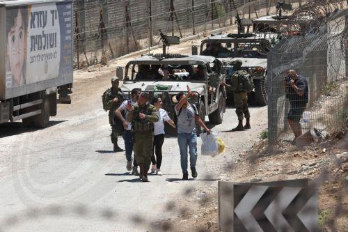 epa12242737 Druze people walk at the ceasefire line between Golan Heights and Syria as they make their way back to Syria, near the Druze village of Majdal Shams, in the Golan Heights, 17 July 2025. Syrian government officials and Druze minority leaders reached a new ceasefire agreement on 16 July, after the previous one collapsed, following days of clashes...