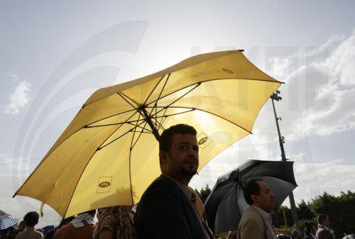 epa12245996 People hold umbrellas to shield themselves from the sun amid hot weather in Sana'a, Yemen, 18 July 2025. Yemen's national meteorological service warned about hot weather with temperatures ranging between 32 and 43 degrees Celsius across most parts of the Arab country.  EPA/YAHYA ARHAB