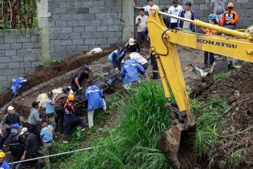 epa12260617 Emergency responders retrieve the body of a worker a day after a landslide hit a construction site following days of typhoon-driven rains, in Cavite province, south of Manila, Philippines, 25 July 2025. At least two people died as a workers' area was buried under a landslide on 24 July, following days of monsoon rains and the passing of Typhoon...