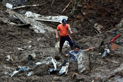 epaselect epa12260612 A Philippine Coast Guard personnel and a worker search the site of a landslide that hit a construction site following days of typhoon-driven rains, in Cavite province, south of Manila, Philippines, 25 July 2025. At least two people died as a workers' area was buried under a landslide on 24 July, following days of monsoon rains and the...