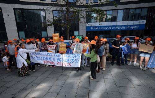 epa12260757 Striking resident doctors display a banner during a picket outside the Royal Liverpool University Hospital in Liverpool, Britain, 25 July 2025. Resident doctors in the UK have begun a five-day strike over pay restoration, demanding a 29 percent pay increase in order to restore the value of their salaries to 2008 levels and keep up with...