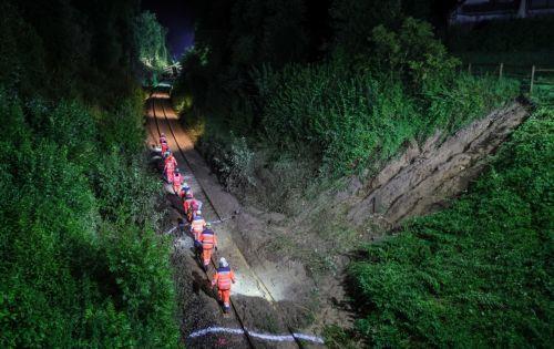epaselect epa12266958 Emergency workers walk next to a landslide near the accident site of a derailed passenger train near Riedlingen, Germany, 28 July 2025. According to the police and fire department, three people died and dozens were injured.  EPA/RONALD WITTEK