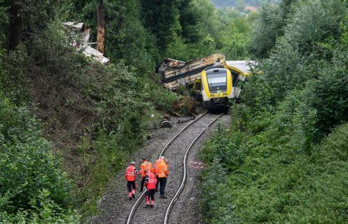 epa12267659 Emergency workers of German Railroad company (DB) stand on the railway track in front a derailed passenger train near Riedlingen, Germany, 28 July 2025. According to the police and fire department, three people died and around 50 were injured.  EPA/RONALD WITTEK