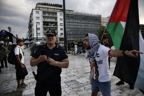 epa12275622 A Palestinian living in Greece gestures to a police officer after being verbally attacked by a woman supporting Israel during a rally against Israel's ongoing operations in the Gaza Strip, in central Athens, Greece 31 July 2025.  EPA/YANNIS KOLESIDIS
