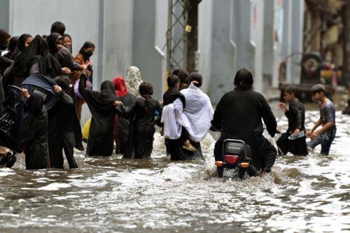 epa12282407 People wade through through heavy monsoon rains in Lahore, Pakistan, 03 August 2025. The Pakistan Meteorological Department warns that the currently weak monsoon currents are set to intensify 04 to 07 of August, bringing further rain and storms to Lahore and central Punjab.  EPA/RAHAT DAR 92299