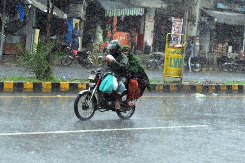 epa12282414 Men ride a motocycle through through heavy monsoon rains in Lahore, Pakistan, 03 August 2025. The Pakistan Meteorological Department warns that the currently weak monsoon currents are set to intensify 04 to 07 of August, bringing further rain and storms to Lahore and central Punjab.  EPA/RAHAT DAR 92299