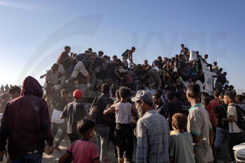 epaselect epa12283323 Internally displaced Palestinians climb aid trucks to get food near a food distribution point in the Morag corridor, south of Khan Younis, in the southern Gaza Strip, 04 August 2025.  EPA/HAITHAM IMAD