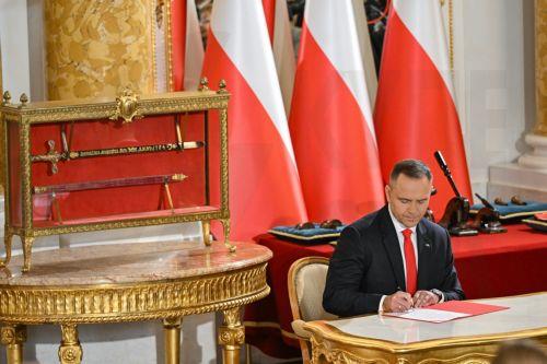 epa12286332 Polish President Karol Nawrocki signs documents during the investiture ceremony of the President of the Republic of Poland as Grand Master of the Order of the White Eagle and Order of Polonia Restituta at the Royal Castle in Warsaw, Poland, 06 August 2025. Karol Nawrocki was sworn in before Poland's parliament for a five-year term of office on...