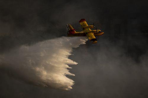 epaselect epa12292878 A hydroplane drops water to extinguish a forest fire near the village of Maceda, Galicia province, northwestern Spain, 10 August 2025. The fire ignited at five or six points almost simultaneously, prompting the Galician government to declare an emergency level 2 due to its proximity to A Teixeira, a neighborhood within Maceda. The...