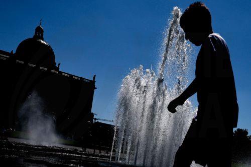 epa12295213 A boy walks next to a public fountain during a hot day in central Berlin, Germany, 12 August 2025.  EPA/FILIP SINGER
