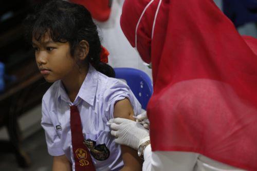 epa12311441 A health worker (R) from the community health center carries out a cervical cancer and rubella vaccination for a Banda Aceh Methodist School student (L) in Banda Aceh, Indonesia, 20 August 2025. Cervical cancer vaccination, including the human papillomavirus vaccine and rubella vaccination, is carried out for school children in specific grades...