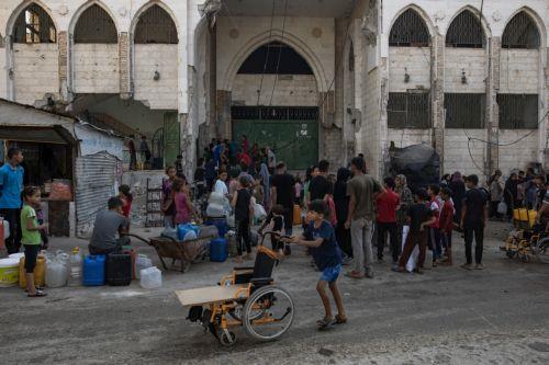 epa12319444 Displaced Palestinians wait to fill containers with drinking water amid the destruction in the Khan Younis camp, southern Gaza Strip, 24 August 2025. According to the UN around 90 per cent of the population or 1.9 million people in Gaza have been displaced since the start of the conflict.  EPA/HAITHAM IMAD