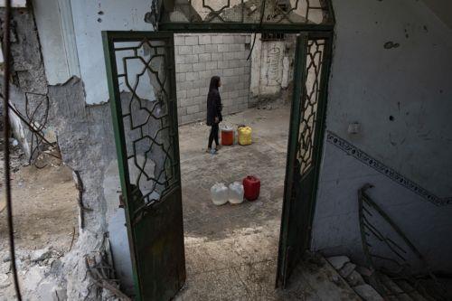 epa12319450 Displaced Palestinians wait to fill containers with drinking water amid the destruction in the Khan Younis camp, southern Gaza Strip, 24 August 2025. According to the UN around 90 per cent of the population or 1.9 million people in Gaza have been displaced since the start of the conflict.  EPA/HAITHAM IMAD