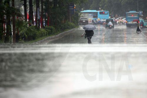 epa12321230 A person holding an umbrella walks under the rain in Hanoi, Vietnam, 25 August 2025. Typhoon Kajiki made landfall on 25 August, bringing torrential rains to Vietnam's north-central coast, prompting mass evacuations and the closure of airports and schools.  EPA/LUONG THAI LINH
