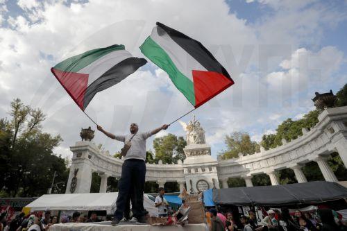 epa12379048 A person holds Palestinian flags during a protest against gentrification in Mexico City, Mexico, 14 September 2025. Activists and displaced people in the Mexican capital participated in a 'gentrification rally' to protest the lack of access to decent housing, rising rents, and the increase in evictions, leading up to the 2026 World Cup. ...