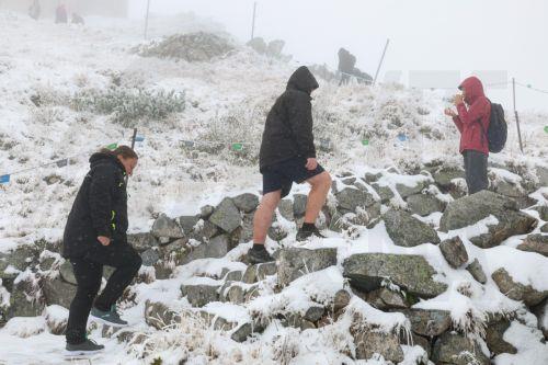 epa12414577 Tourists walk during a snowfall in Kasprowy Wierch, near Zakopane, in the Tatra Mountains, southern Poland, 29 September 2025. Temperatures at Kasprowy Wierch were recorded at minus 2 degrees Celsius.  EPA/GRZEGORZ MOMOT POLAND OUT