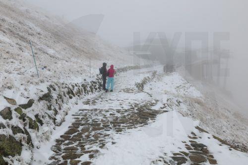 epa12414578 Tourists walk during a snowfall in Kasprowy Wierch, near Zakopane, in the Tatra Mountains, southern Poland, 29 September 2025. Temperatures at Kasprowy Wierch were recorded at minus 2 degrees Celsius.  EPA/GRZEGORZ MOMOT POLAND OUT