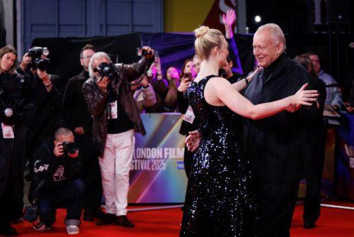 epa12449312 US actor Elle Fanning (L) and Swedish actor Stellan Skarsgard (R) dance on the red carpet as they arrive for the gala screening of 'Sentimental Value' during the BFI London Film Festival at Royal Festival Hall in London, Britain, 12 October 2025. The 69th edition of the annual film festival runs from 08 to 19 October 2025.  EPA/TOLGA AKMEN