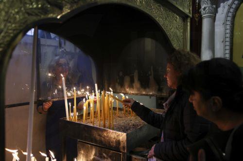 Γυναίκα ανάβει κερί κατά τη διάρκεια της Δοξολογίας στο ναό του Αγίου Δημητρίου, για την εορτή του Πολιούχου της Θεσσαλονίκης, στο πλαίσιο των Εορταστικών εκδηλώσεων των Επετείων της 26ης Οκτωβρίου 1912, ημέρας απελευθέρωσης της πόλης από τον τουρκικό ζυγό, εορτής του Πολιούχου Αγίου Δημητρίου και της 28ης Οκτωβρίου 1940, την Κυριακή 26 Οκτωβρίου 2025....