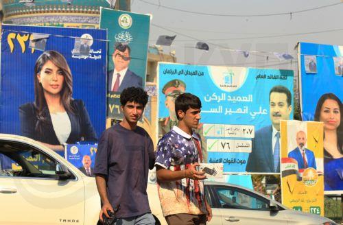 epa12510558 Iraqis walk past election campaigning posters ahead of the parliamentary elections in Baghdad, Iraq, 07 November 2025. Iraq is preparing to hold legislative elections on 11 November 2025.  EPA/CEERWAN AZIZ
