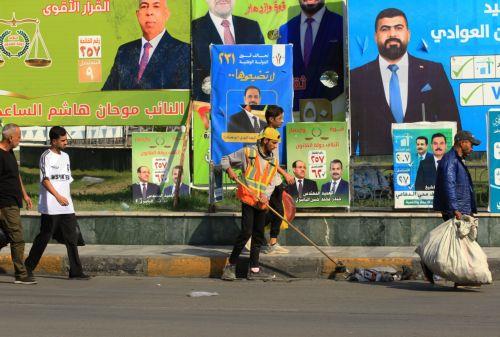 epa12510557 Iraqis walk past election campaigning posters ahead of the parliamentary elections in Baghdad, Iraq, 07 November 2025. Iraq is preparing to hold legislative elections on 11 November 2025.  EPA/CEERWAN AZIZ