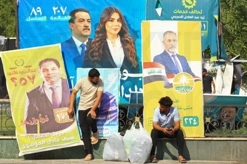 epa12510559 Iraqis sit next to election campaigning posters ahead of the parliamentary elections in Baghdad, Iraq, 07 November 2025. Iraq is preparing to hold legislative elections on 11 November 2025.  EPA/CEERWAN AZIZ