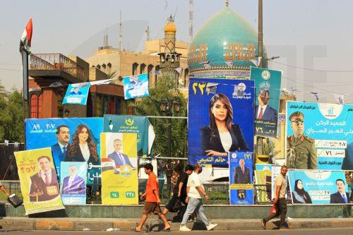 epa12510562 Iraqis walk past election campaigning posters ahead of the parliamentary elections in Baghdad, Iraq, 07 November 2025. Iraq is preparing to hold legislative elections on 11 November 2025.  EPA/CEERWAN AZIZ