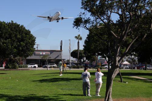 epa12511513 People watch as an airplane descends for landing at Los Angeles International Airport (LAX) in Los Angeles, California, USA, 07 November 2025. US airlines started canceling hundreds of flights on 07 November 2025, hours after the Federal Aviation Administration (FAA) ordered the cuts amid the current US government shutdown.  EPA/ALLISON DINNER