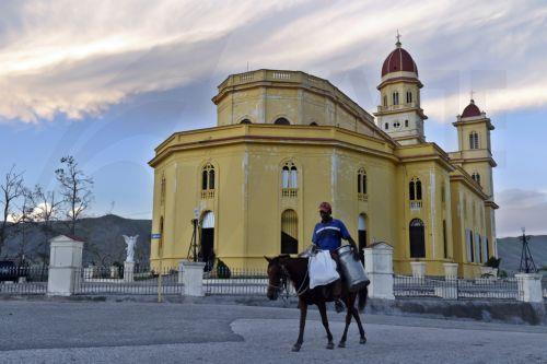 epa12511557 A person rides a horse passing by the Church of Our Lady of Charity in El Cobre, Santiago de Cuba, Cuba, 07 November 2025. The five Cuban provinces severely affected by Hurricane Melissa on 29 October are beginning to gradually restore services, although authorities have warned that the damage is extensive and that normalization will take time. ...