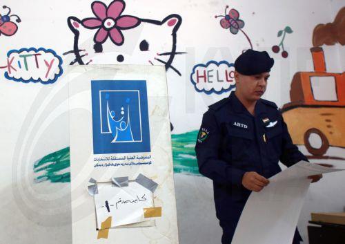 epa12513472 A member of the Iraqi security forces holds a ballot paper during the early voting for the parliamentary elections, in Baghdad, Iraq, 09 November 2025. Members of the security forces and the military are casting their ballots in early voting for the Iraqi parliamentary elections before the general vote on 11 November.  EPA/CEERWAN AZIZ