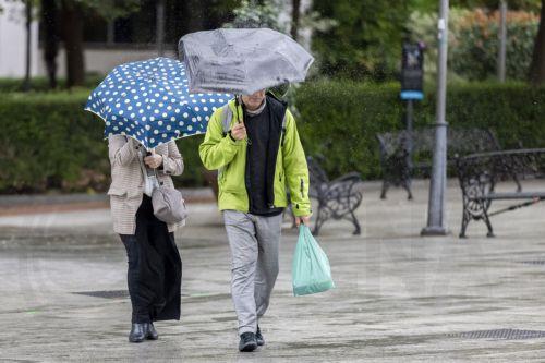 epa12522866 Two pedestrians cross a park as strong winds and rainfall hit Huelva, Andalusia, western Spain, 13 November 2025. Spanish weather authority issued an orange alert in Huelva for heavy rainfalls and strong winds as storm Claudia crosses the country.  EPA/Alberto Díaz