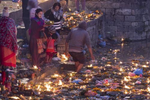 epa12534860 Nepalese devotees release oil lamps at the Bagmati River in memory of deceased family members as they observe the Balachaturdashi festival at the Pashupati temple in Kathmandu, Nepal, 19 November 2025. Thousands of people from all over the country have gathered at the Pasupati temple to light oil lamps on the Bagmati River in honor of their...
