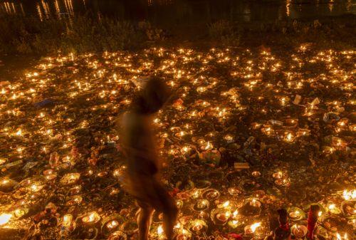 epa12534859 A Nepalese devotee gathers around oil lamps at the Bagmati River in memory of deceased family members during the Balachaturdashi festival at Pashupati temple in Kathmandu, Nepal, 19 November 2025. Thousands of people from all over the country have gathered at the Pasupati temple to light oil lamps on the Bagmati River in honor of their departed...