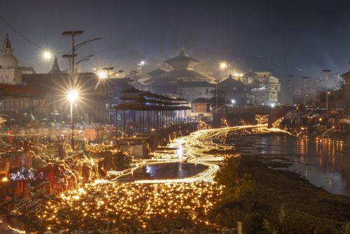 epa12534863 Nepalese devotees release oil lamps at the Bagmati River in memory of deceased family members as they observe the Balachaturdashi festival at Pashupati temple in Kathmandu, Nepal, 19 November 2025. Thousands of people from all over the country have gathered at the Pasupati temple to light oil lamps on the Bagmati River in honor of their departed...